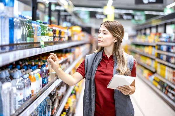 Trade promotion manager inspecting products in a supermarket